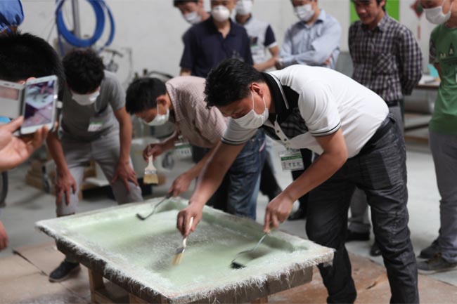 噴涂完成后，用輥筒壓實玻纖